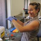 A smiling woman standing in a laboratory setting
