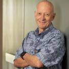 Portrait of a man in a blue shirt leaning against a wall